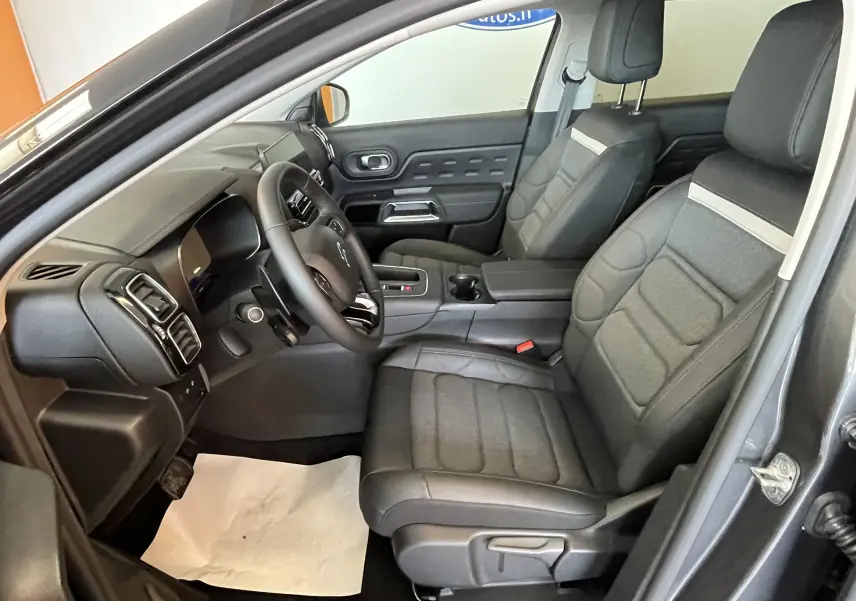 Vue intérieure côté conducteur du Citroën C5 Aircross gris platinium 2025, sièges tissu/TEP et volant cuir croûte.