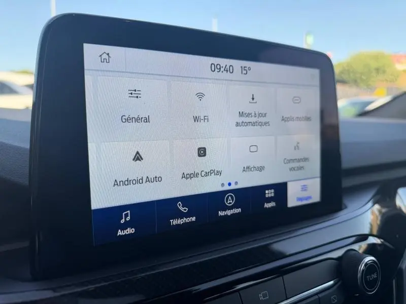 Écran tactile central du Ford Kuga 2024 affichant les options connectivité et réglages, intérieur noir.