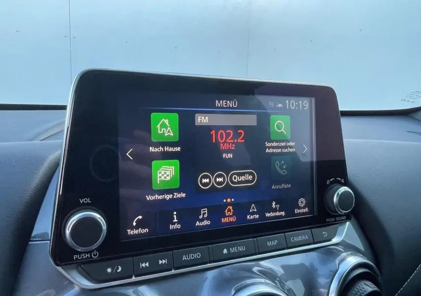 Écran tactile central du Nissan Juke 2024 affichant le menu radio avec commandes autour, intérieur noir.