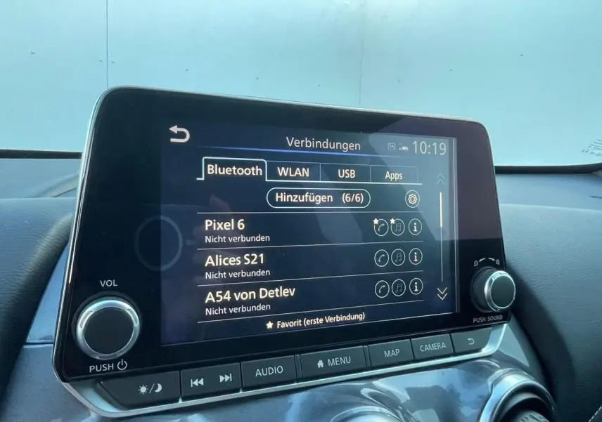 Écran tactile central du Nissan Juke 2024 affichant les options Bluetooth, avec commandes audio et climatisation visibles.