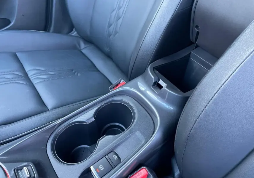 Gros plan sur l'accoudoir central noir et les deux porte-gobelets du Nissan Juke II 2024, sellerie TEP noire.