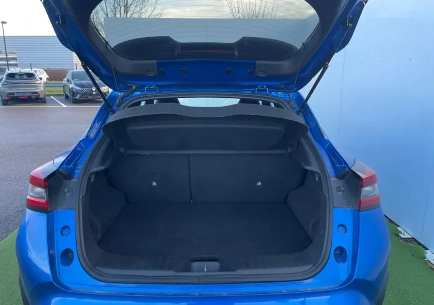 Coffre ouvert d'un Nissan Juke II 2024 bleu magnetic, vue arrière montrant l'espace de chargement vide.