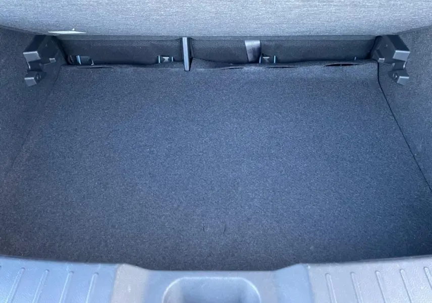 Coffre vide du Nissan Juke II 2024, vue intérieure arrière avec revêtement noir et plancher plat.