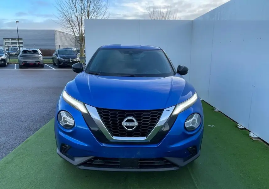 Vue avant d'un Nissan Juke II 2024 bleu magnetic avec calandre en V chromée et phares LED fins.