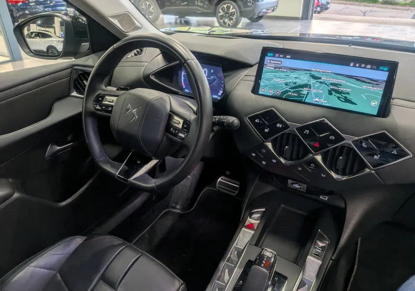 Vue intérieure côté conducteur du DS3 2024, tableau de bord noir avec écran tactile et volant cuir siglé DS.