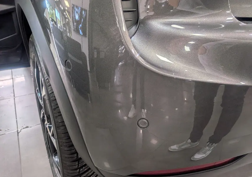 Gros plan sur l'aile arrière droite gris Platinium du DS3 2024 avec capteurs de stationnement intégrés.