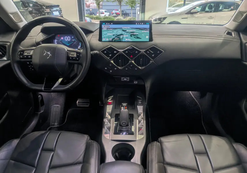 Intérieur noir cuir du DS3 2024 avec tableau de bord moderne et écran tactile central en vue frontale.