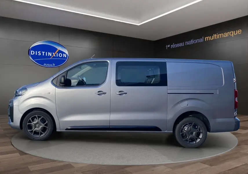 Profil gauche d'un Citroën Jumpy Cabine Approfondie gris acier avec jantes noires et vitres teintées en showroom.