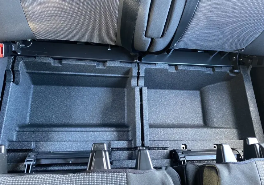 Rangement sous la banquette arrière du Citroën Jumpy Cabine Approfondie gris acier, vue plongeante sur les compartiments ouverts.