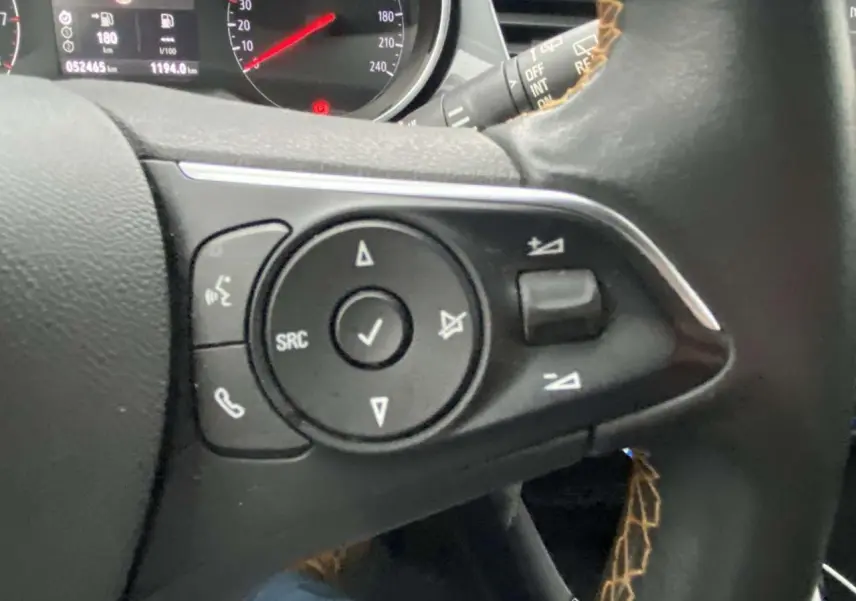 Gros plan sur les commandes au volant noir de l'Opel Crossland X 2020 avec tableau de bord en arrière-plan.