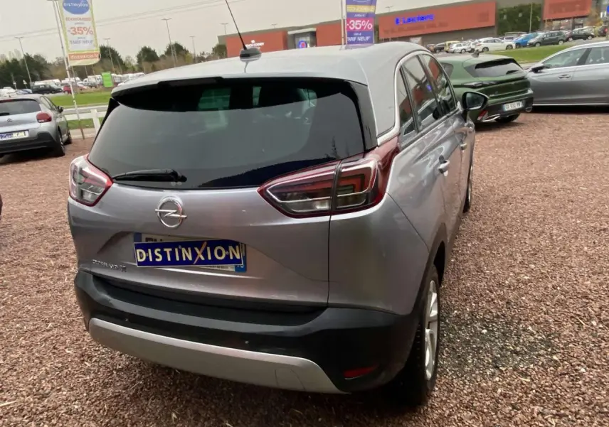 Vue 3/4 arrière droite d'un Opel Crossland X gris métallisé avec vitres surteintées et jantes alliage 16 pouces.
