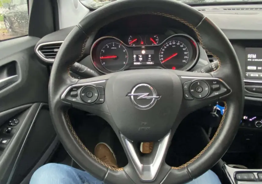 Vue intérieure centrée sur le volant noir de l'Opel Crossland X 2020 avec tableau de bord et commandes visibles.