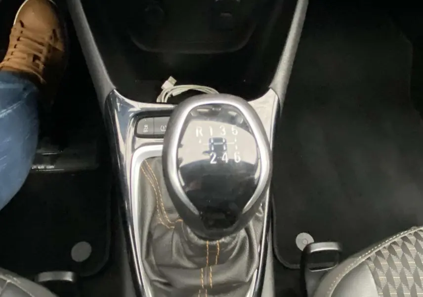 Le levier de vitesses manuel noir avec coutures orange de l'Opel Crossland X Elégance vue en gros plan intérieur.