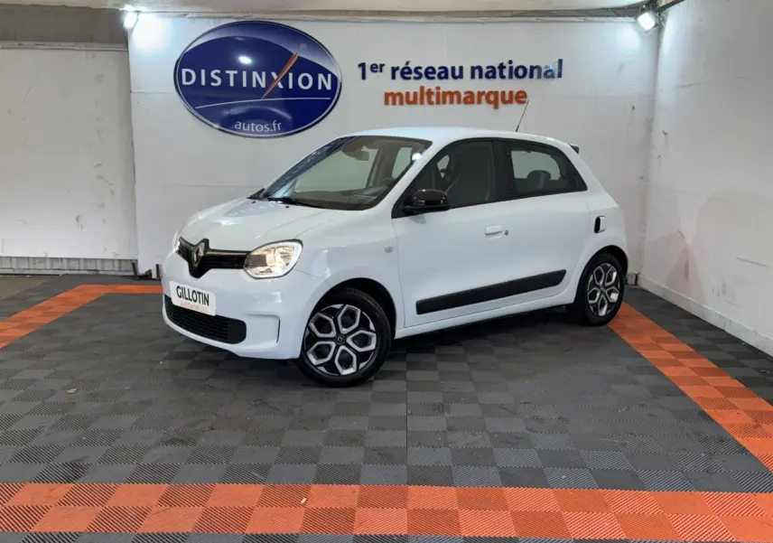 Renault Twingo Equilibre blanc vue 3/4 avant droit en intérieur, avec jantes spécifiques et rétroviseurs noirs.