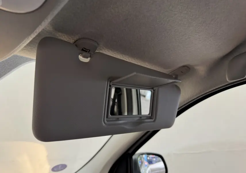 Miroir de courtoisie ouvert sur le pare-soleil côté conducteur de la Renault Twingo blanche, vue intérieure rapprochée.