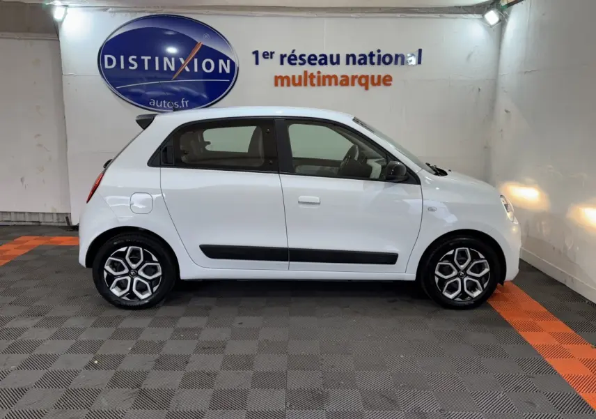 Profil côté gauche d'une Renault Twingo blanche 2022, version Equilibre SCe 65, avec jantes distinctives et poignées intégrées.