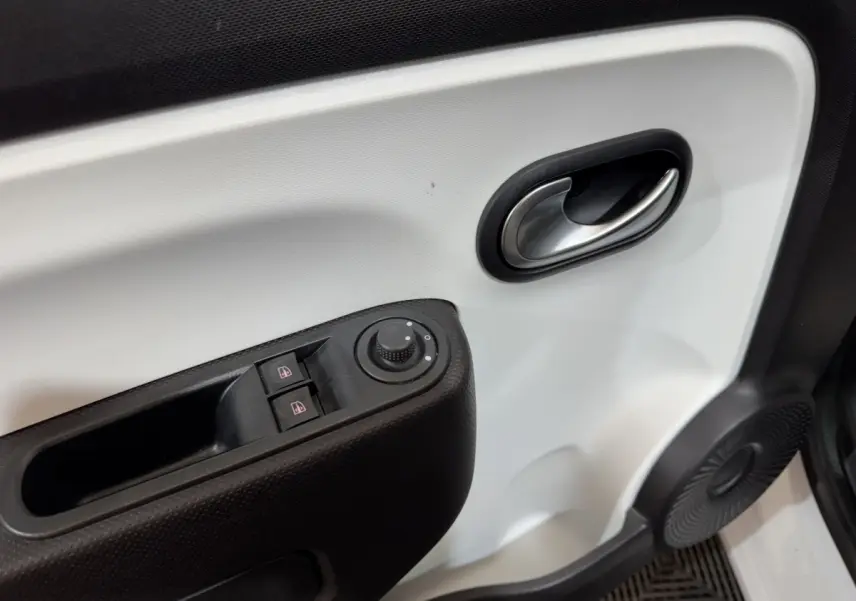 Gros plan sur la porte intérieure blanche côté conducteur de la Renault Twingo Equilibre 2022 avec commandes de vitres et rétroviseurs.
