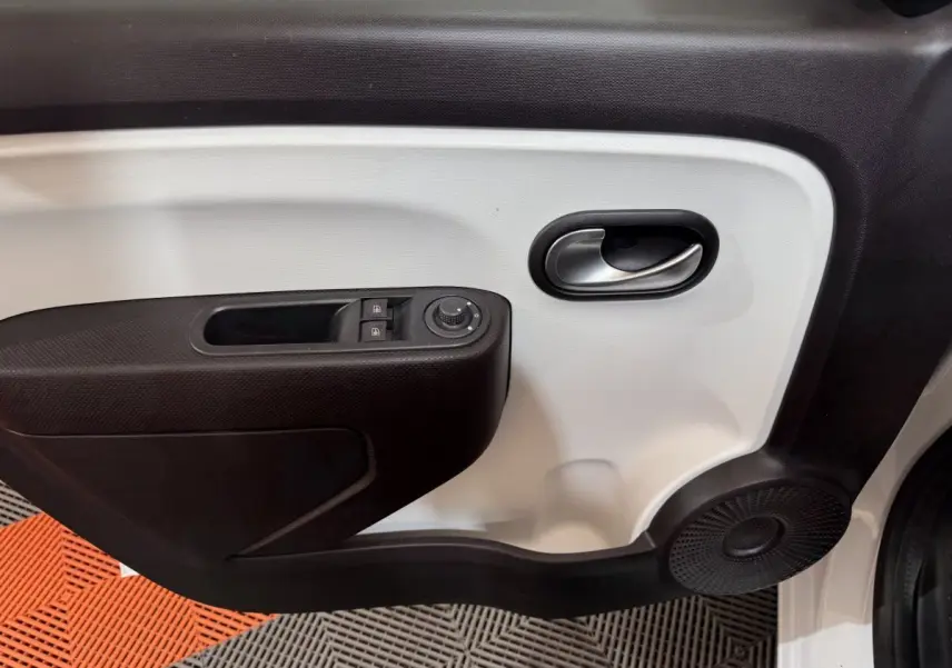 Gros plan sur la porte avant gauche blanche de la Renault Twingo 2022 avec commandes de vitres et haut-parleur intégré.