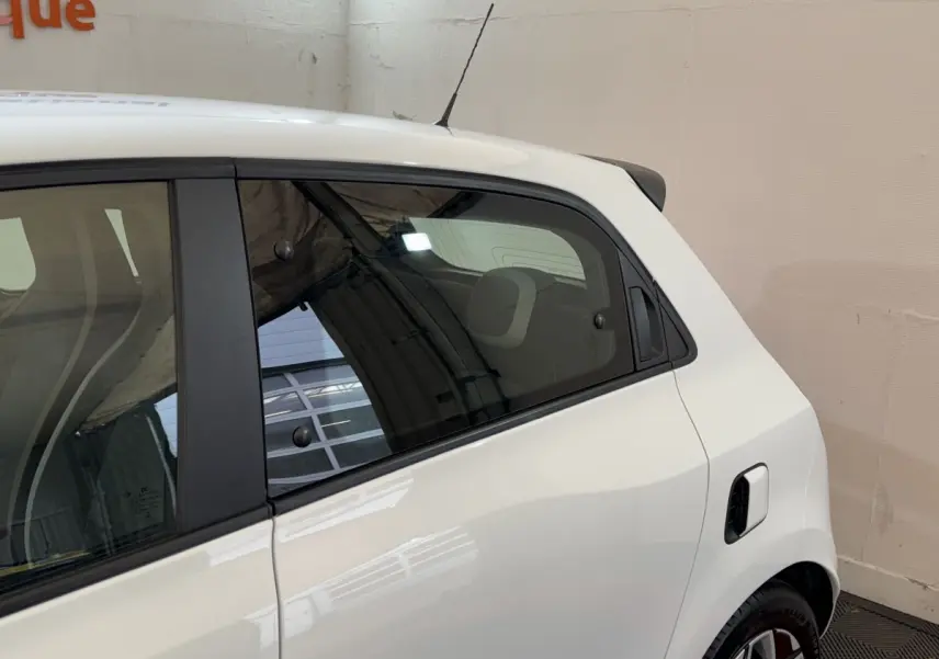 Vue latérale droite sur la partie arrière d'une Renault Twingo blanche avec antenne et jante alliage visible.