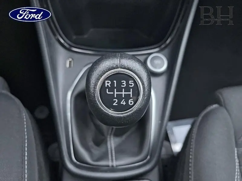 Gros plan sur le levier de vitesse cuir noir d'une Ford Puma blanc Glacier, boîte manuelle 6 rapports, intérieur tissu noir.