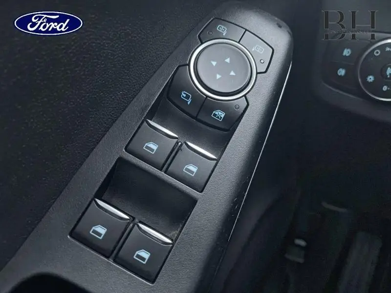 Gros plan sur les commandes électriques des vitres et rétroviseurs côté conducteur du Ford Puma blanc Glacier 2020.