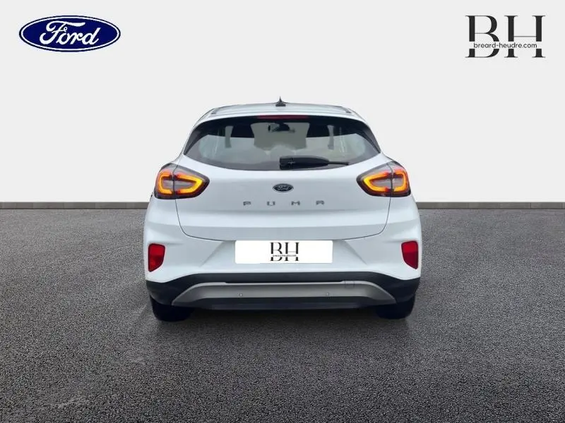 Vue arrière d'une Ford Puma blanc glacier de 2020 avec feux arrière LED allumés et hayon électrique mains libres.