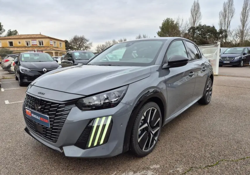 Peugeot 208 Hybrid gris vue 3/4 avant droit, avec feux diurnes verticaux distinctifs et jantes alliage 17 pouces.