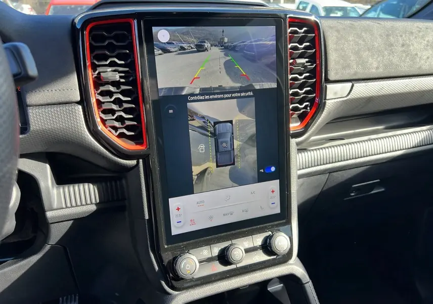 Vue rapprochée de la console centrale du Ford Ranger Raptor 2025 avec écran tactile affichant caméra 360°, entouré de détails rouges.