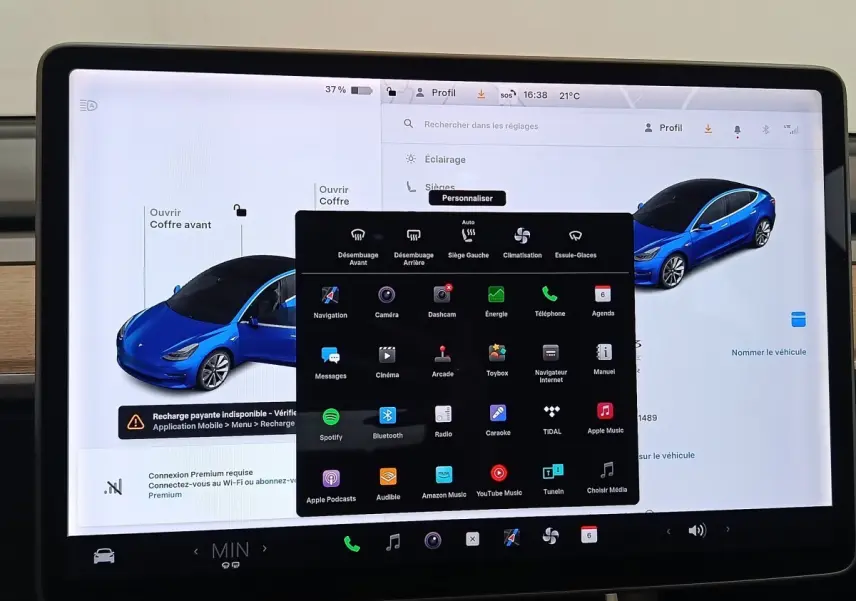Écran tactile central affichant les réglages et une vue 3/4 avant d'une Tesla Model 3 bleu électrique.