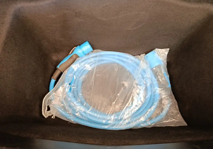 Câble de recharge bleu emballé dans le coffre avant d'une Tesla Model 3 Long Range 2020.