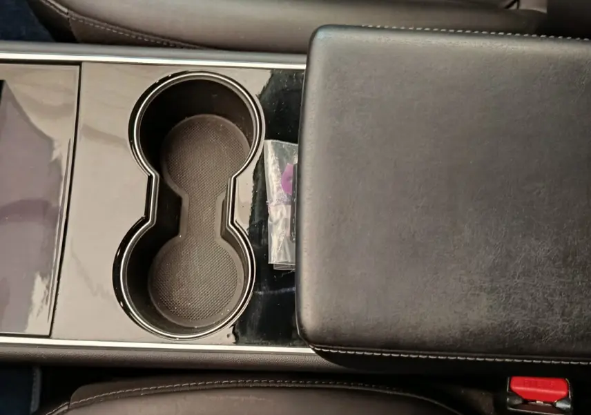 Gros plan sur la console centrale noire avec porte-gobelets et accoudoir en cuir du Tesla Model 3 Long Range 2020.