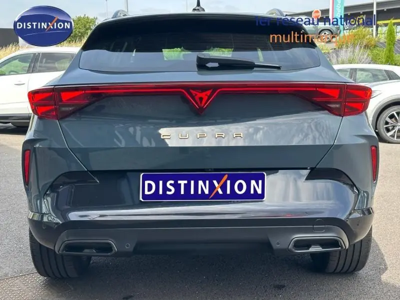 Vue arrière d'une CUPRA Formentor bleu Fjord 2025 avec feux LED reliés et double sortie d'échappement intégrée.