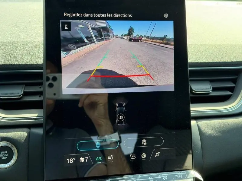 Écran tactile intérieur montrant la caméra de recul du Renault Captur gris Rafale, avec guidage de trajectoire coloré.