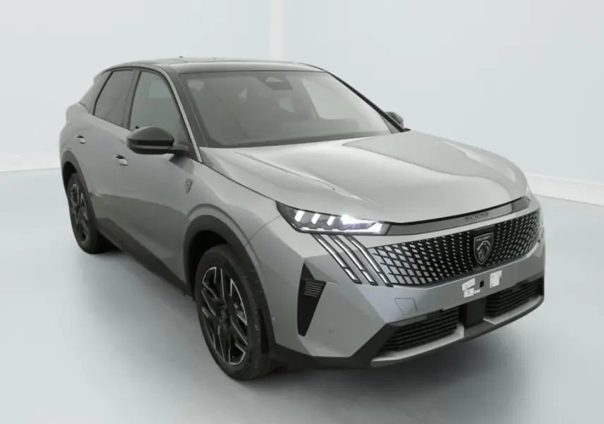 Peugeot 3008 1.2 Hybrid 145 GT gris, vue 3/4 avant avec calandre distinctive et phares LED allumés.