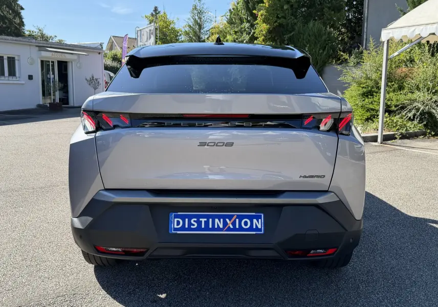 Vue arrière d’un Peugeot 3008 gris clair hybride 2025 avec feux arrière LED et toit noir brillant.