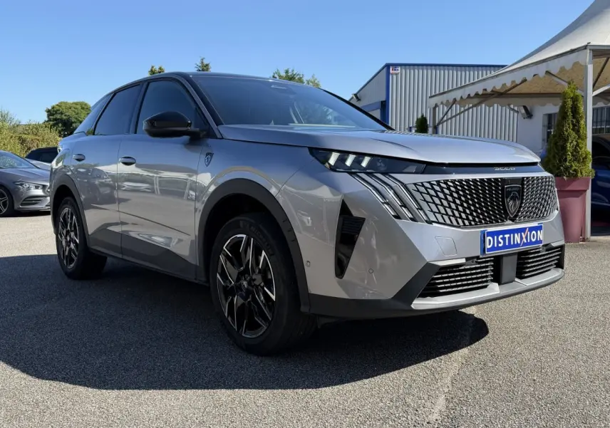Peugeot 3008 gris clair en 3/4 avant droit, avec calandre noire distinctive et jantes alliage noires.
