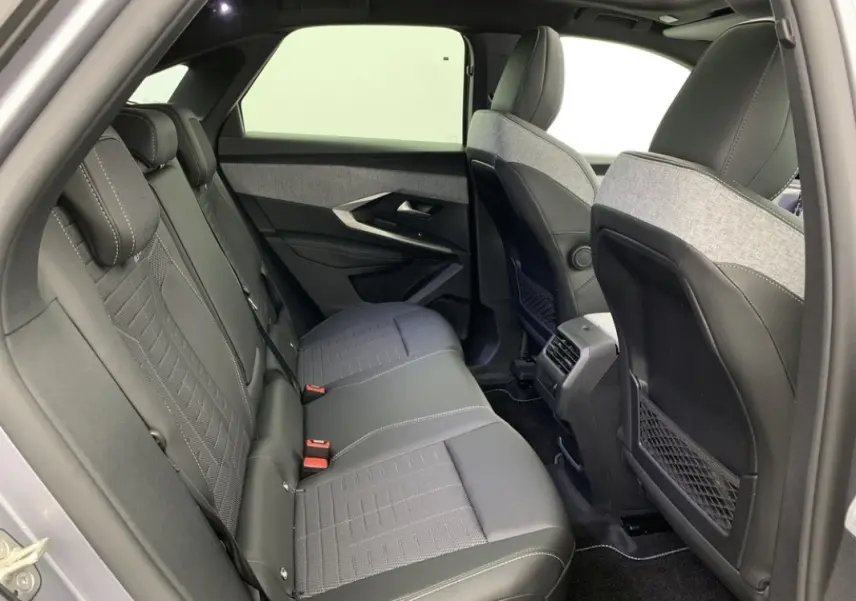 Vue intérieure arrière côté gauche du Peugeot 3008 2025 avec sièges en cuir noir et tissu gris clair.