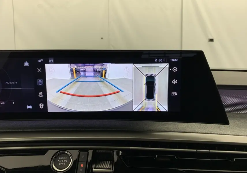 Écran tactile intérieur du Peugeot 3008 montrant l’aide au stationnement avec vue arrière et vue aérienne du véhicule.
