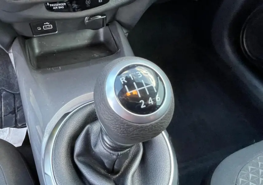 Le levier de vitesses manuel noir du Nissan Juke 2024, avec indication des six rapports et marche arrière.