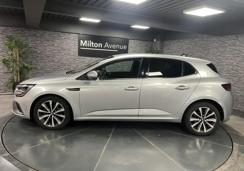 Profil droit d'une Renault Mégane gris Highland 2022 en finition R.S. Line, avec jantes alliage 17 pouces et antenne aileron de requin.