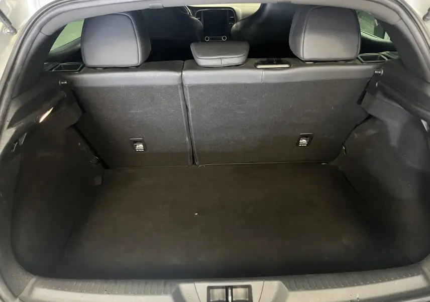 Coffre ouvert de la Renault Mégane gris, vue arrière montrant l'espace de chargement et les dossiers de sièges rabattables.