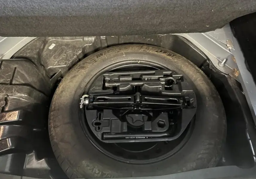 Roue de secours avec outillage intégré dans le coffre d'une Renault Mégane gris Highland 2022.