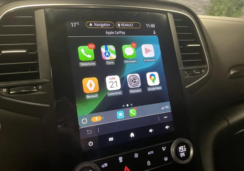 Écran tactile multimédia Renault Mégane 2022 affichant Apple CarPlay, entouré de commandes noires du tableau de bord.
