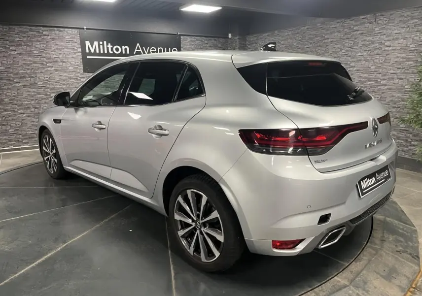 Renault Mégane gris Highland vue 3/4 arrière droit avec feux LED et double sortie d’échappement chromée.