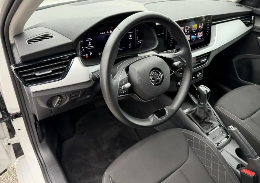 Vue intérieure côté conducteur de la Skoda Scala blanche 2023, avec tableau de bord numérique et écran tactile central.