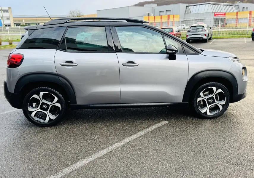 Profil côté gauche du Citroën C3 Aircross gris Artense avec toit noir Perla Nera et jantes alliage 17 pouces.