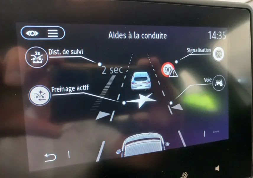 Écran tactile de la Renault Clio Business blanc montrant l'aide à la conduite avec freinage actif et signalisation 90 km/h.
