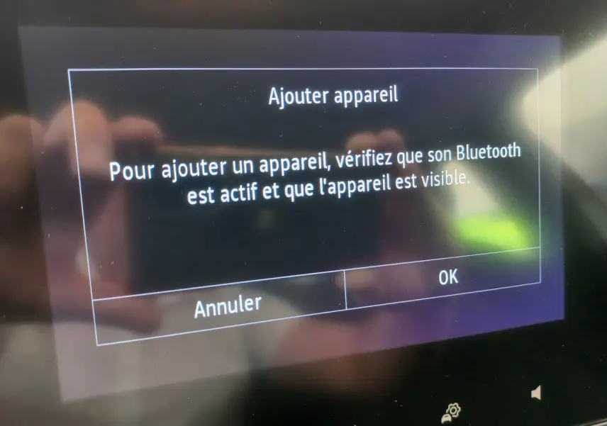 Écran tactile central de la Renault Clio Business blanc 2021 affichant un message d'ajout Bluetooth.