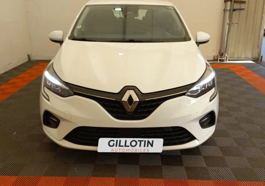 Vue avant d'une Renault Clio Business blanche avec phares LED allumés et calandre noire brillante.