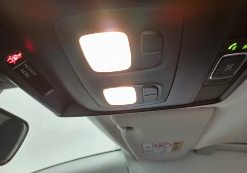 Plafonnier intérieur allumé avec commandes et panneau de signalisation dans une Renault Clio Business blanche de 2021.